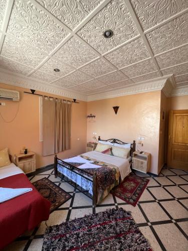 穆莱伊德里斯蒂亚尔迪美酒店的一间卧室设有两张床和格子天花板