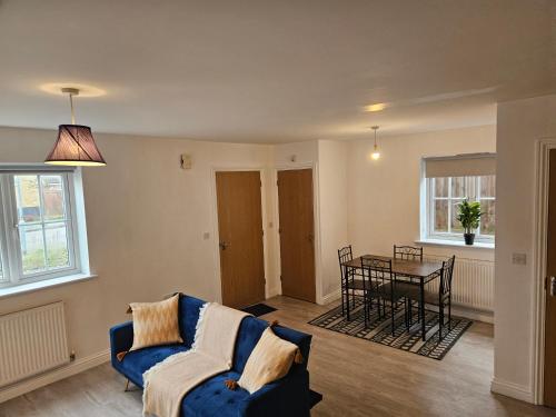 巴塞尔顿Impeccable 2-Bed House in Basildon的客厅配有蓝色的沙发和桌子
