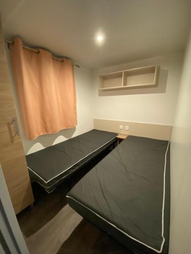 维亚斯Mobilhome的小房间,配有床和窗帘
