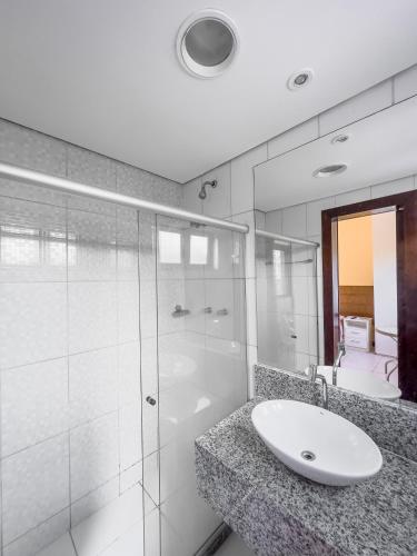 伊塔帕里卡Itaparica Praia Hotel的一间带水槽和玻璃淋浴的浴室