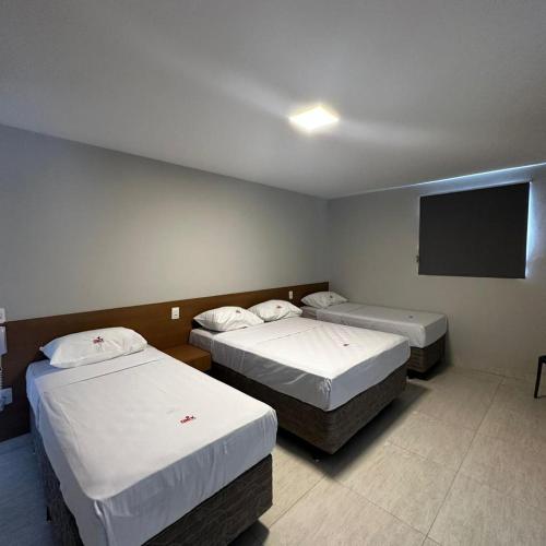萨尔瓦多ONIX AGUAS CLARAS的客房设有两张床和一台平面电视。