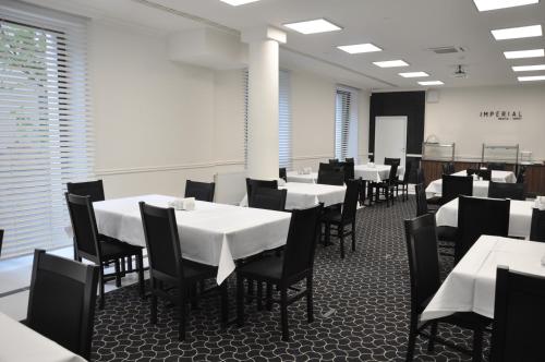 索波特Rewita Imperial的用餐室配有白色桌子和黑色椅子