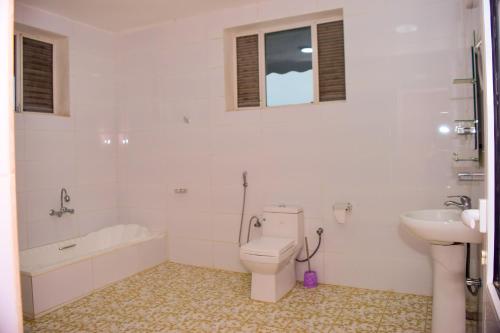 布琼布拉lake palace beach hotel的白色的浴室设有卫生间和水槽。