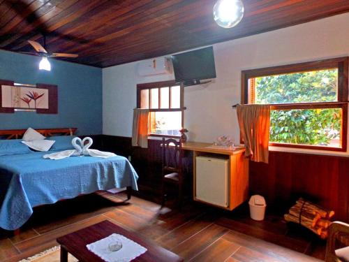 维奥康德马奥Hotel Cantinho de Férias的一间卧室配有一张床、一张桌子和一个窗户。