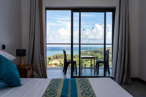 Rodrigues IslandLe Marin, Rodrigues Island的一间卧室配有一张床,享有海景