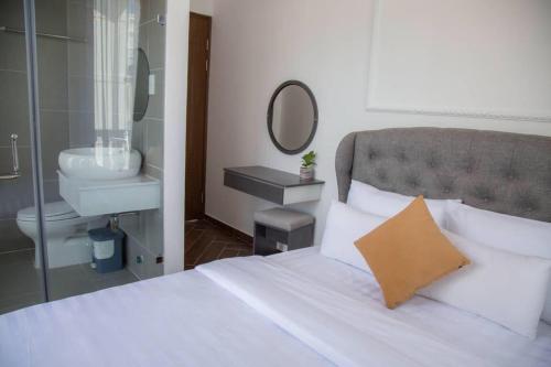 阿普春安Căn hộ tại Đà Lạt的卧室配有白色床、水槽和镜子