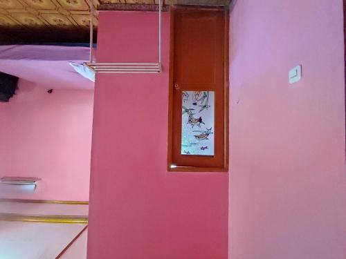 肯达利OYO 93299 Homestay Aqsa的粉红色的冰箱,上面有照片