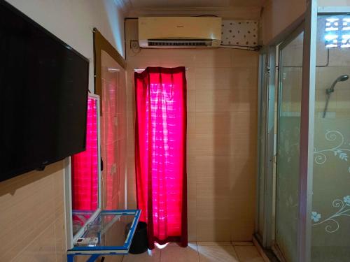 肯达利OYO 93278 Wisma Syariah Lahundape的一间在客房内配有红色窗帘的浴室