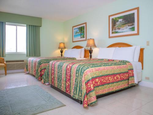 科罗萨尔Princess Vegas Hotel & Casino的配有2盏灯的酒店客房的2张床