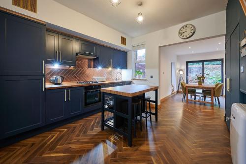 利物浦Host & Stay - 19 Garswood的厨房配有蓝色橱柜和木制台面