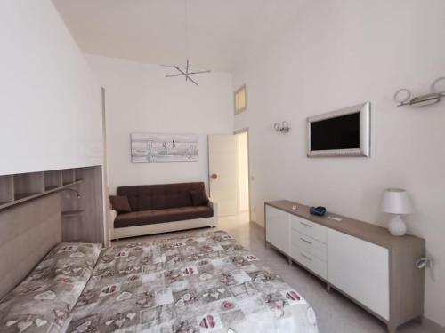 加埃塔La Pescheria Casa Vacanze的一间卧室配有一张床和一张沙发