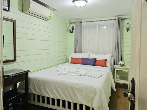 曼谷W home The Thai-style tranquil and cozy villa的卧室配有白色的床和色彩缤纷的枕头