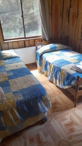 PichareCasa tranquila amueblada的客房设有两张床和窗户。