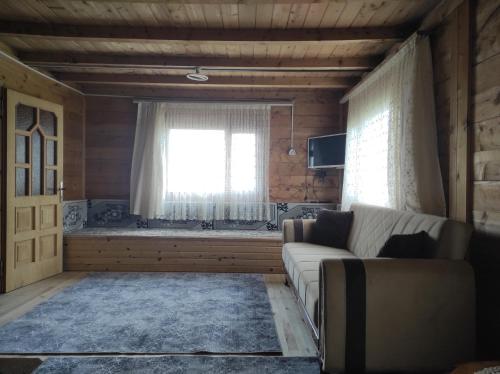 Sultan Murat Yaylasi比尔利克亚伊拉肯特度假屋的带沙发和窗户的客厅