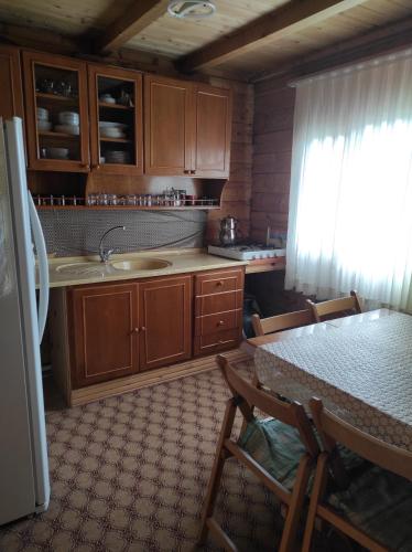 Sultan Murat Yaylasi比尔利克亚伊拉肯特度假屋的厨房配有木制橱柜、桌子和冰箱。