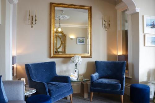 伊斯特布恩新英格兰酒店的一间设有蓝色椅子和镜子的等候室