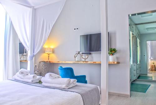FournésFour Seasons Villa Chania的一间卧室,配有床上毛巾和蓝椅