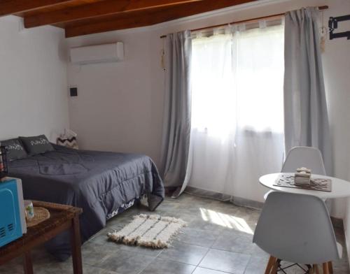 RufinoNómade Habitación的一间卧室配有一张床、一张桌子和一个窗户。