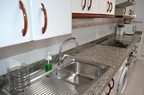 Vivienda Falda del Monsacro的厨房配有不锈钢水槽和白色橱柜