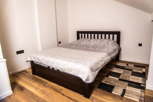 瓦列沃Apartman Tešić的铺有木地板的客房内的一张小床