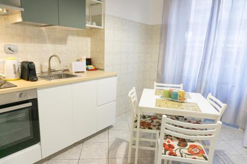 都灵Lingotto Luxury Apartment的厨房配有桌椅和水槽。