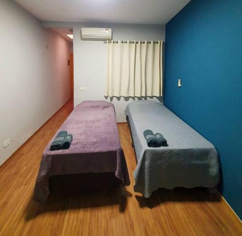 圣保罗Casa 146 - SP Expo, Metrô, Congonhas的配有蓝色墙壁和木地板的客房中的两张床