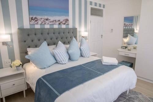 巴利托Modern Luxury Beach House的一间卧室配有一张带蓝白色枕头的大床