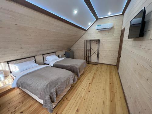 迪利然MaRu House的客房内设有两张床、木地板和电视。