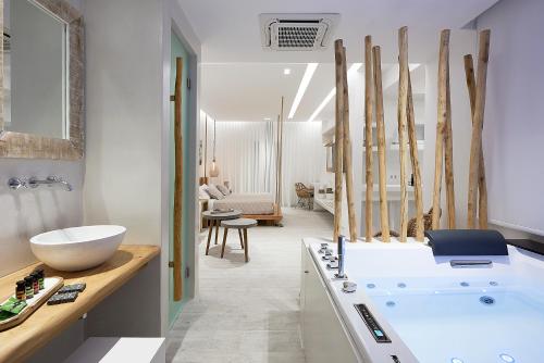阿达玛斯Nirome Luxury Suites的浴室配有白色浴缸和水槽