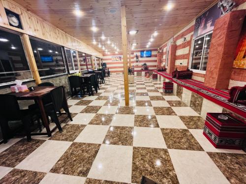 瓦迪穆萨Petra Royal Ranch的餐厅设有棋盘地板和桌椅