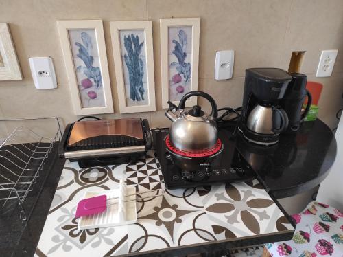 皮雷诺波利斯Odara, Pouso e Acolhimento的厨房柜台配有两个茶壶和炉灶