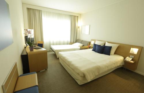 博洛尼亚The Sydney Hotel的一间设有大床和窗户的酒店客房