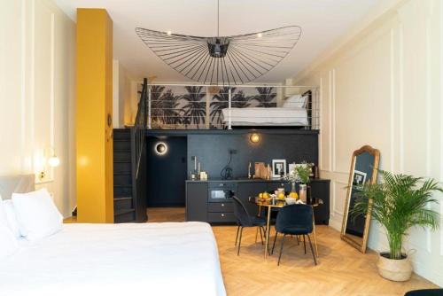 里昂Suite Amalfi的一间卧室配有一张床和一张桌子及椅子