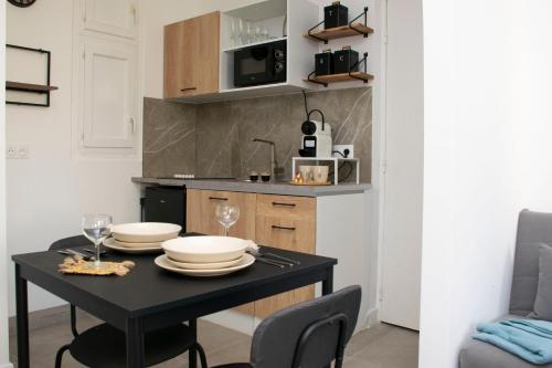 马赛Au Pied du Vieux-Port Wifi Netflix的一间小厨房,配有黑色的桌子和椅子
