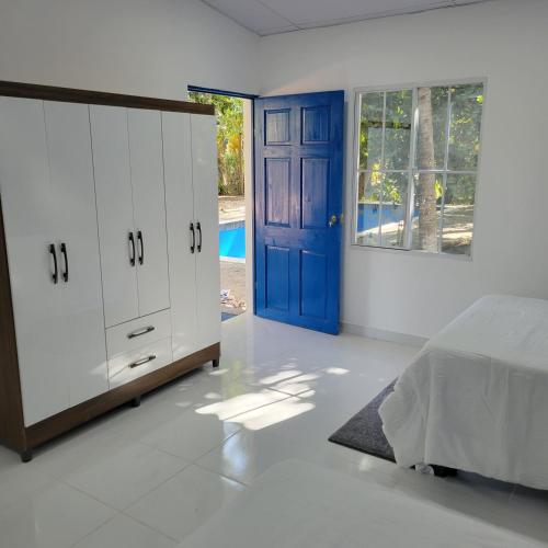 拉利伯塔德RANCHO SARIMAR的一间卧室配有一张床和一个蓝色的门