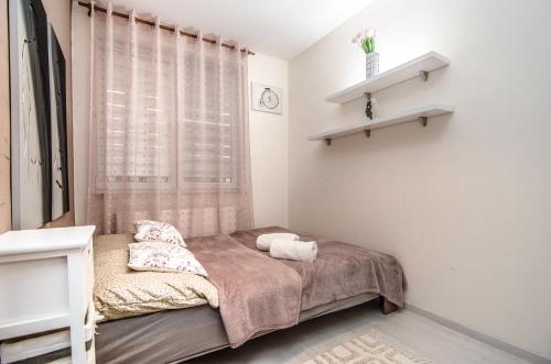科沃布热格Apartament z Ogródkiem - Alldayholiday的一间小卧室,配有床和窗户