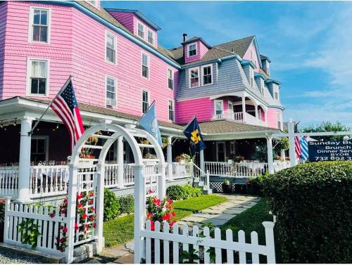 Bay Head格林维尔宾馆及餐厅的粉红色的房子,前面有白色的围栏