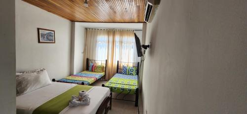 内瓦Luna verde hotel的一间小卧室,配有两张床和窗户