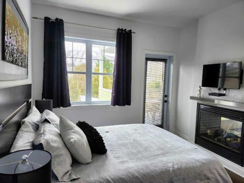 布罗蒙Le 201 Champlain Bromont的一间卧室配有一张带壁炉和电视的床。