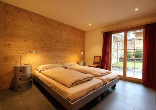 RougemontLuxury Chalet Solidage的一间卧室配有一张木墙床