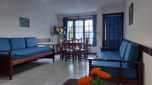 圣卡洛斯-德巴里洛切Lago Gutierrez的客厅配有蓝色的沙发、桌子和椅子