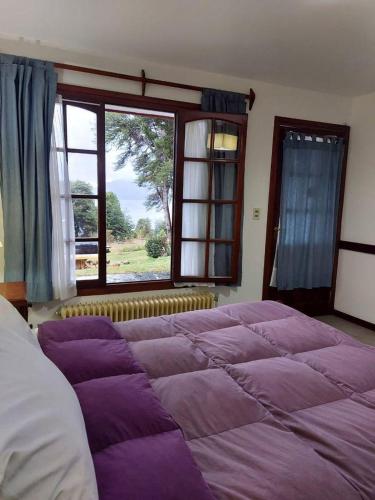 圣卡洛斯-德巴里洛切Lago Gutierrez的卧室设有一张大床,卧室设有大窗户