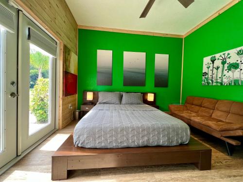 Lake AlfredThe Tatman Evergreen Suite的绿色卧室配有床和沙发