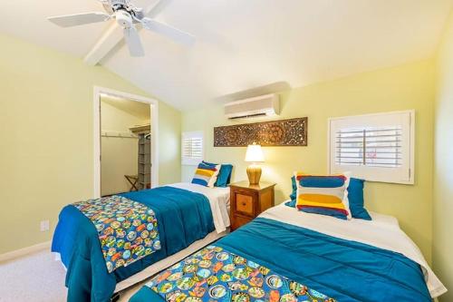 檀香山Villa Ahina的一间卧室配有两张床和吊扇