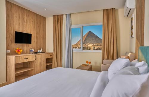 开罗Soul Pyramids View的酒店客房带一张床,能欣赏金字塔美景。