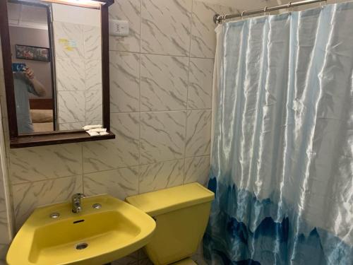 圣地亚哥Hotel Alameda的浴室设有黄色水槽和浴帘