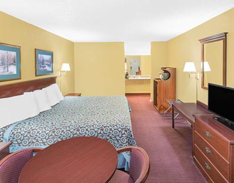 北小石城Travel Inn North Little Rock的配有一张床和一台平面电视的酒店客房