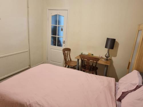 莱斯特Home away from home的一间卧室配有一张床、一张书桌和一个窗户。