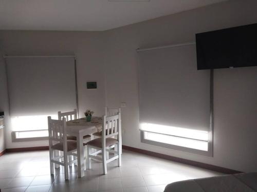 康考迪亚Monoambiente en zona centrica con garage的窗户客房内的白色桌椅