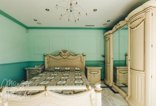 马德里Luxurious 5 Bedroom Apartment in Moncloa-Aravaca的一间卧室配有一张带蓝色墙壁和吊灯的床。